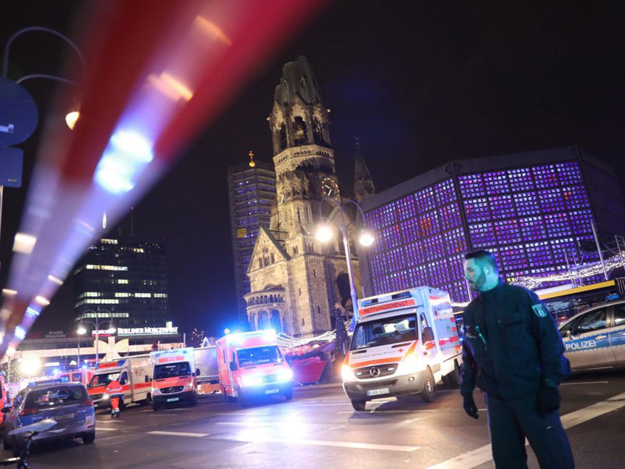 German policemen and rescue workers at the scene where a truck crashed into a Christmas market, close to the Kaiser Wilhelm memorial church in Berlin, Germany