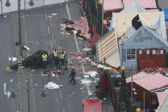 Policemen investigate the scene where a truck ploughed into a crowded Christmas market in Berlin