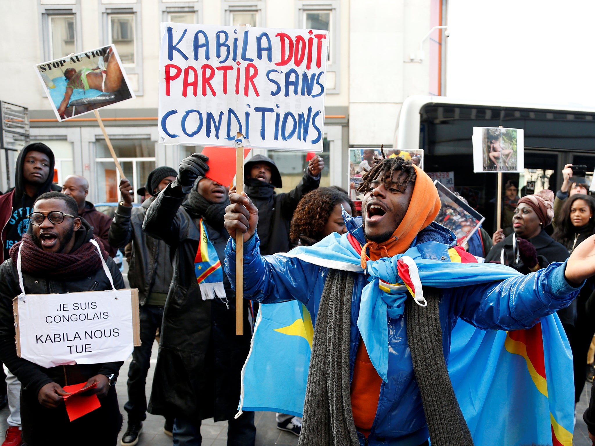 A demonstrator holds a sign reading 'Kabila must leave without any conditions' during a protest against plans of Democratic Republic of Congo's President Joseph Kabila to stay in office past the end of his term