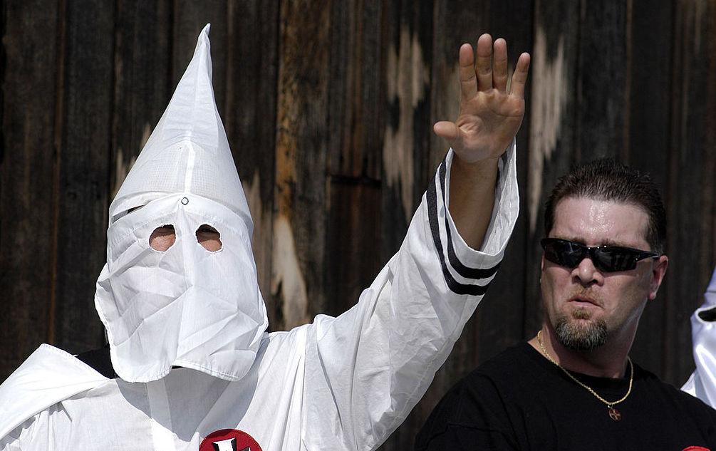 A Ku Klux Klan member salutes during an American Nazi Party rally at Valley Forge National Park September 25, 2004 in Valley Forge, Pennsylvania. Hundreds of American Nazis from around the country were expected to attend.