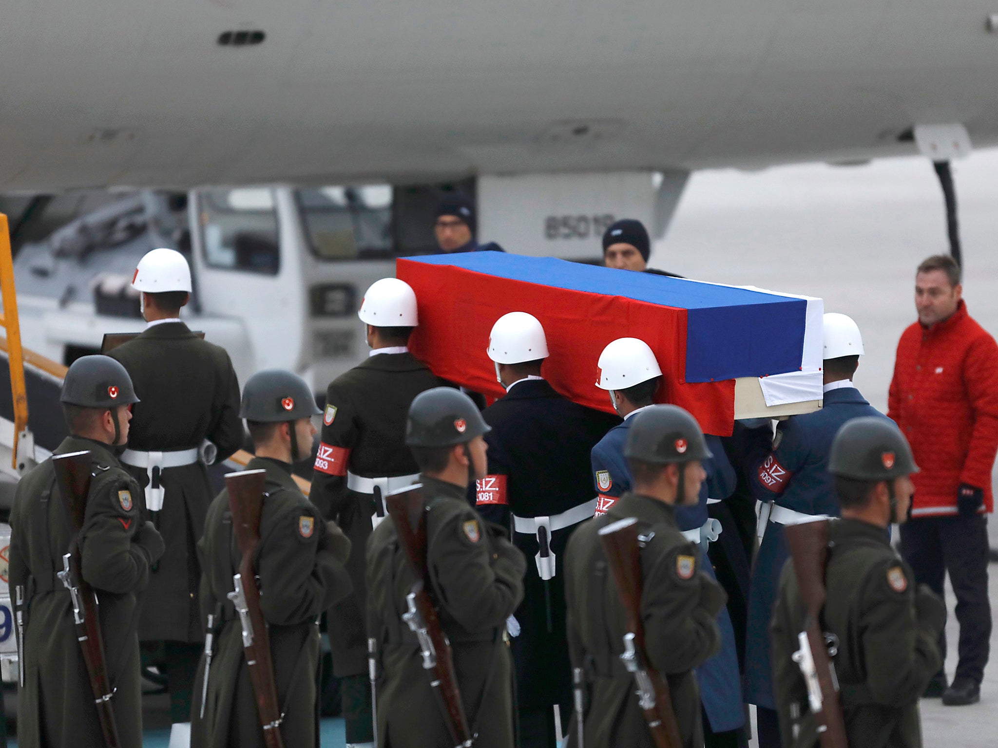 The flag-wrapped coffin of ambassador Andrei Karlov is carried to a plane during a ceremony at Esenboga airport in Ankara