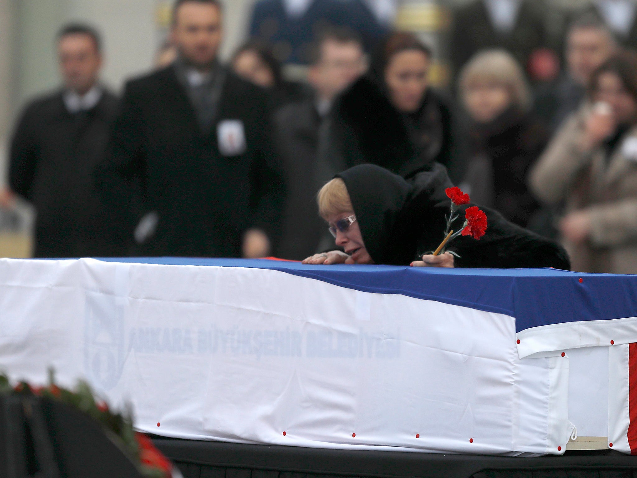 Late Russian Ambassador to Turkey Andrei Karlov's wife Marina mourns next to the flag-wrapped coffin during a ceremony at Esenboga airport in Ankara, Turkey