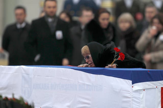 Late Russian Ambassador to Turkey Andrei Karlov's wife Marina mourns next to the flag-wrapped coffin during a ceremony at Esenboga airport in Ankara, Turkey
