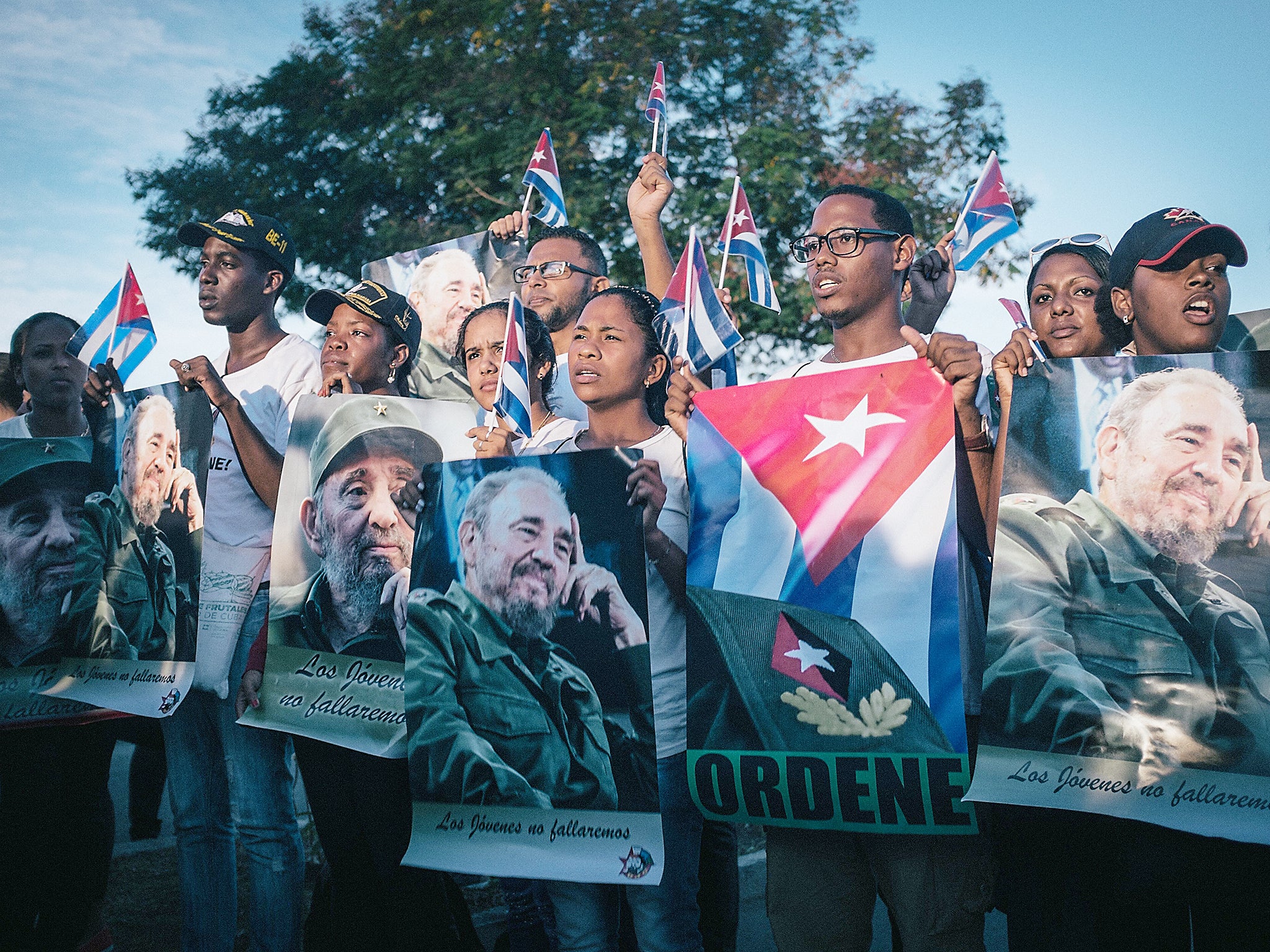 Cuban students holding flags and posters of Fidel Castro outside the Santa Ifigenia Cemetery in Santiago de Cuba