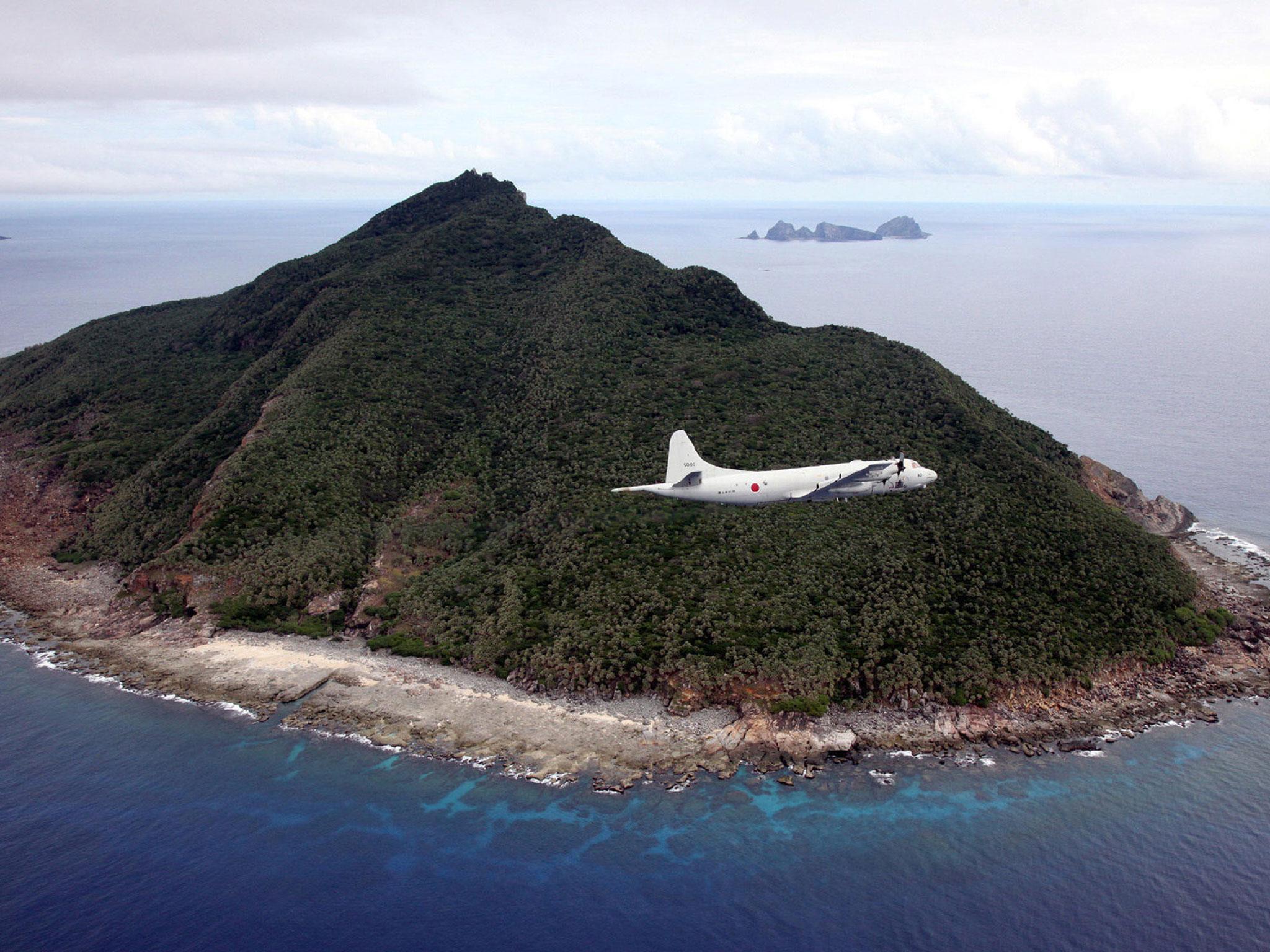 A patrol plane from the Japanese Maritime Self-Defence Force flies over the disputed islets known as the Senkaku islands in Japan and Diaoyu islands in China, in the East China Sea
