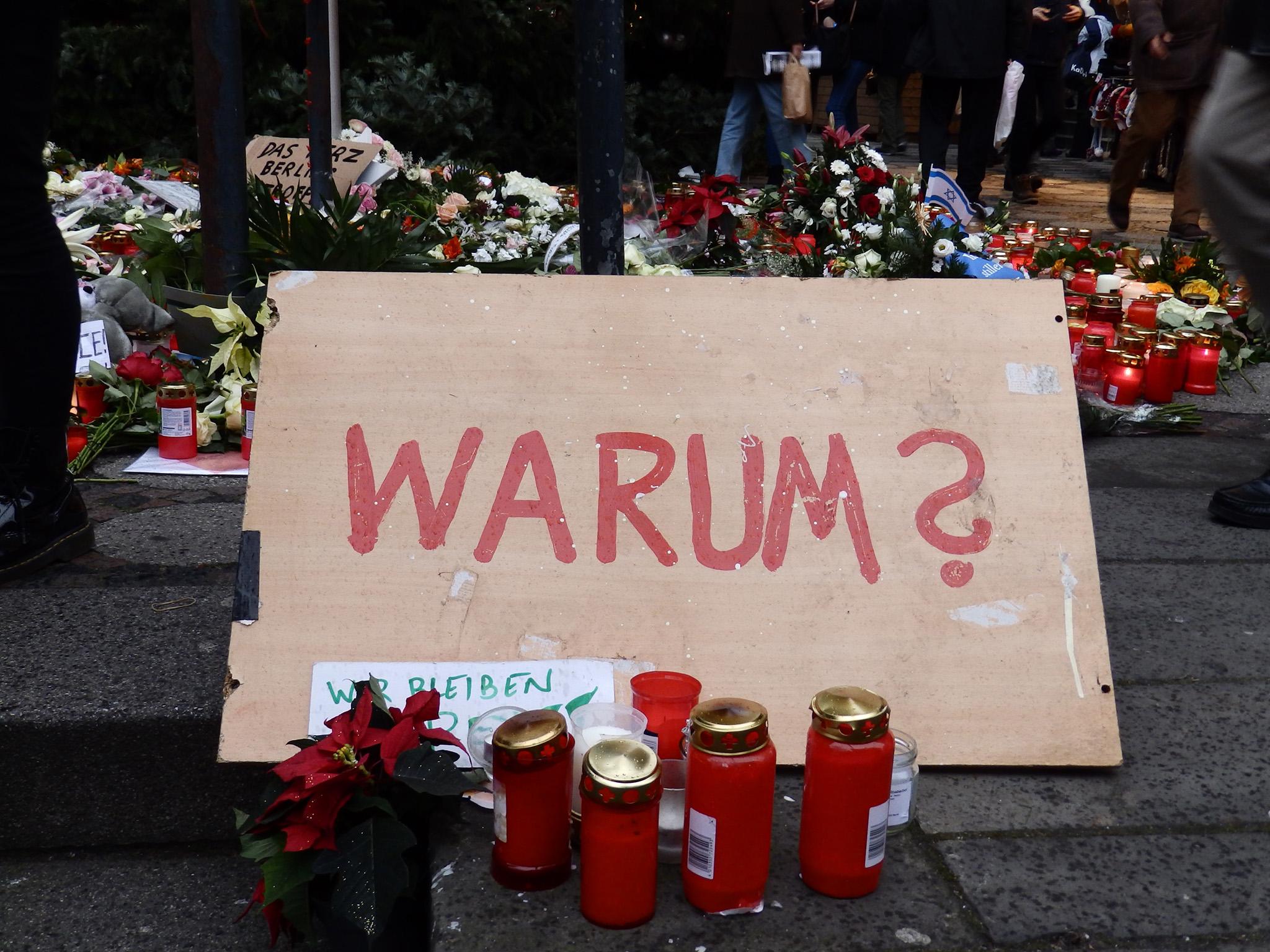 A sign asking ‘why?’ at the reopened Christmas market next to the Kaiser Wilhelm Memorial Church in Berlin