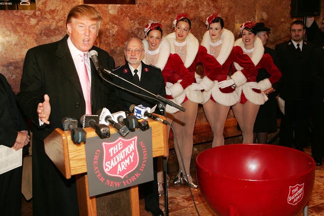 Members of the Radio City Rockettes listen to Donald Trump speaking at a Christmas ceremony in Trump Tower, New York 2004
