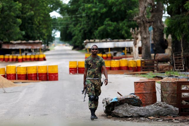 <p>A soldier walks past a checkpoint in the Boko Haram stronghold of Borno State, Nigeria</p>