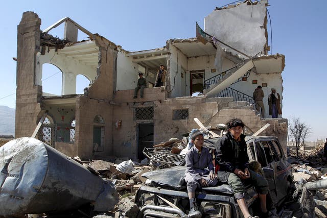 Children sit amidst the rubble of a house hit by Saudi-led coalition air strikes two days earlier on the outskirts of the Yemeni capital Sana’a