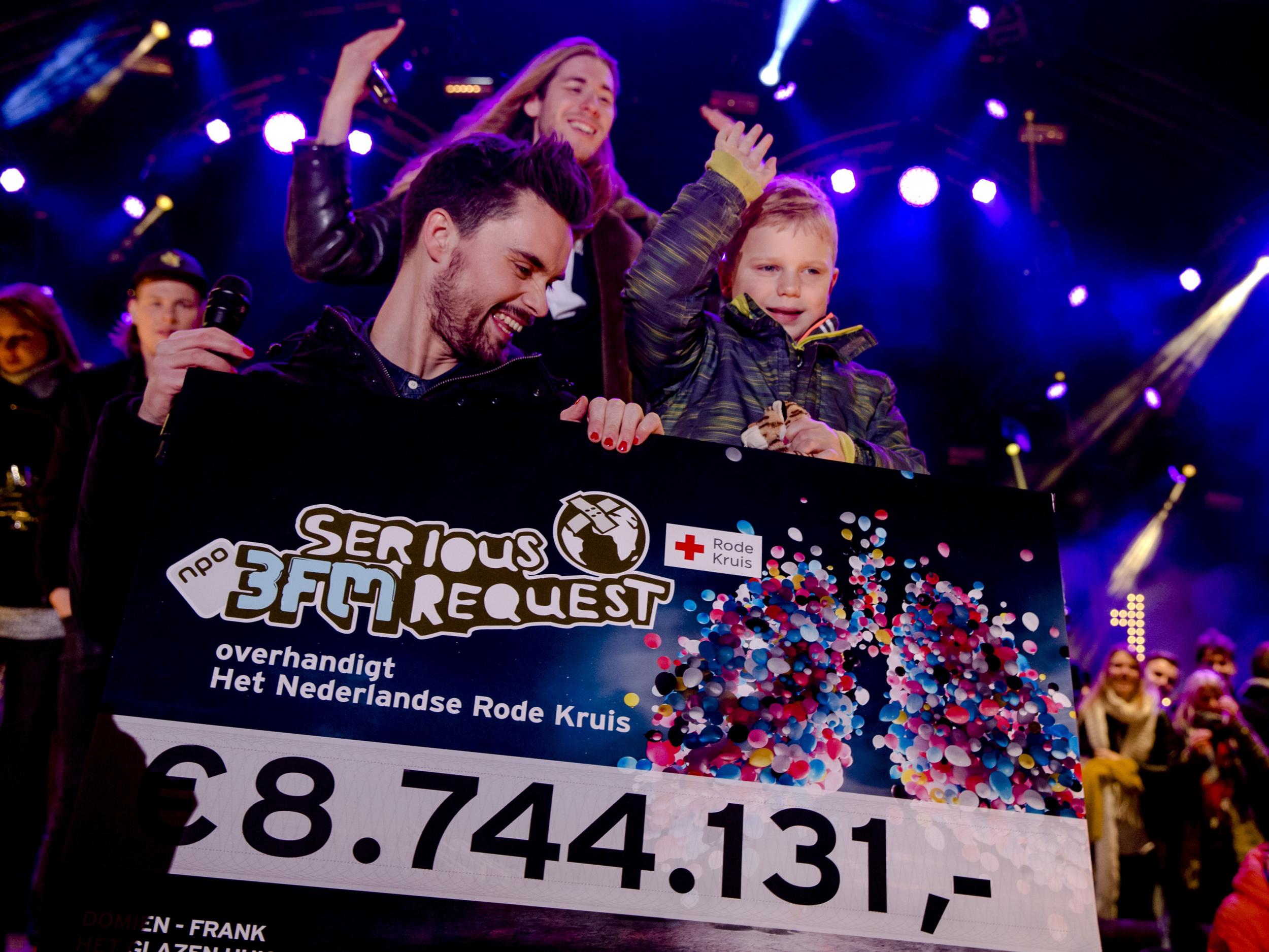Dutch radio DJ's and 6-year-old Tijn Kolsteren show the combined total amount of money (8,744,131 euros) they raised