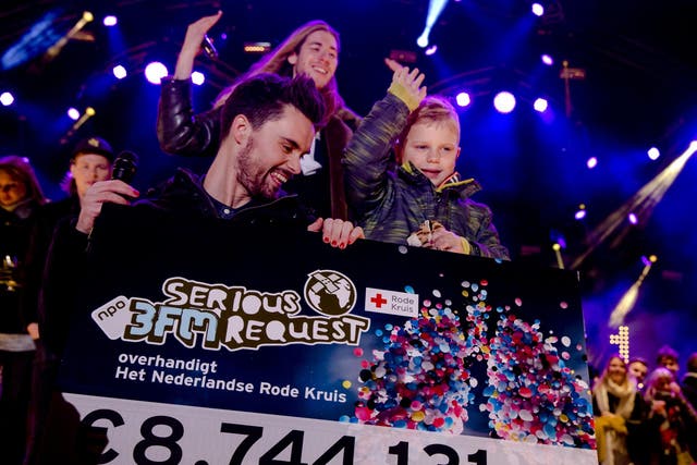 Dutch radio DJ's and 6-year-old Tijn Kolsteren show the combined total amount of money (8,744,131 euros) they raised