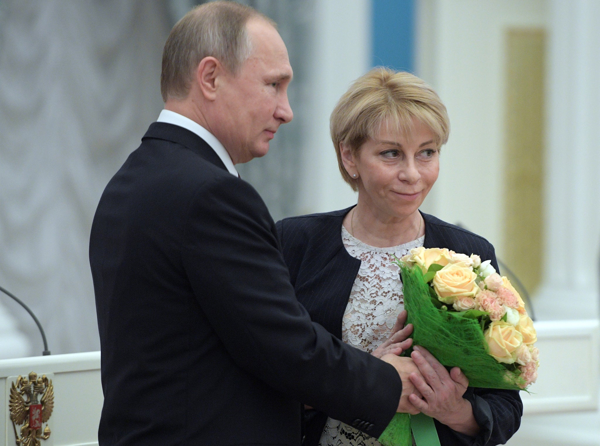 A picture taken on December 8, 2016 shows Russian President Vladimir Putin offering flowers to Yelizaveta Glinka