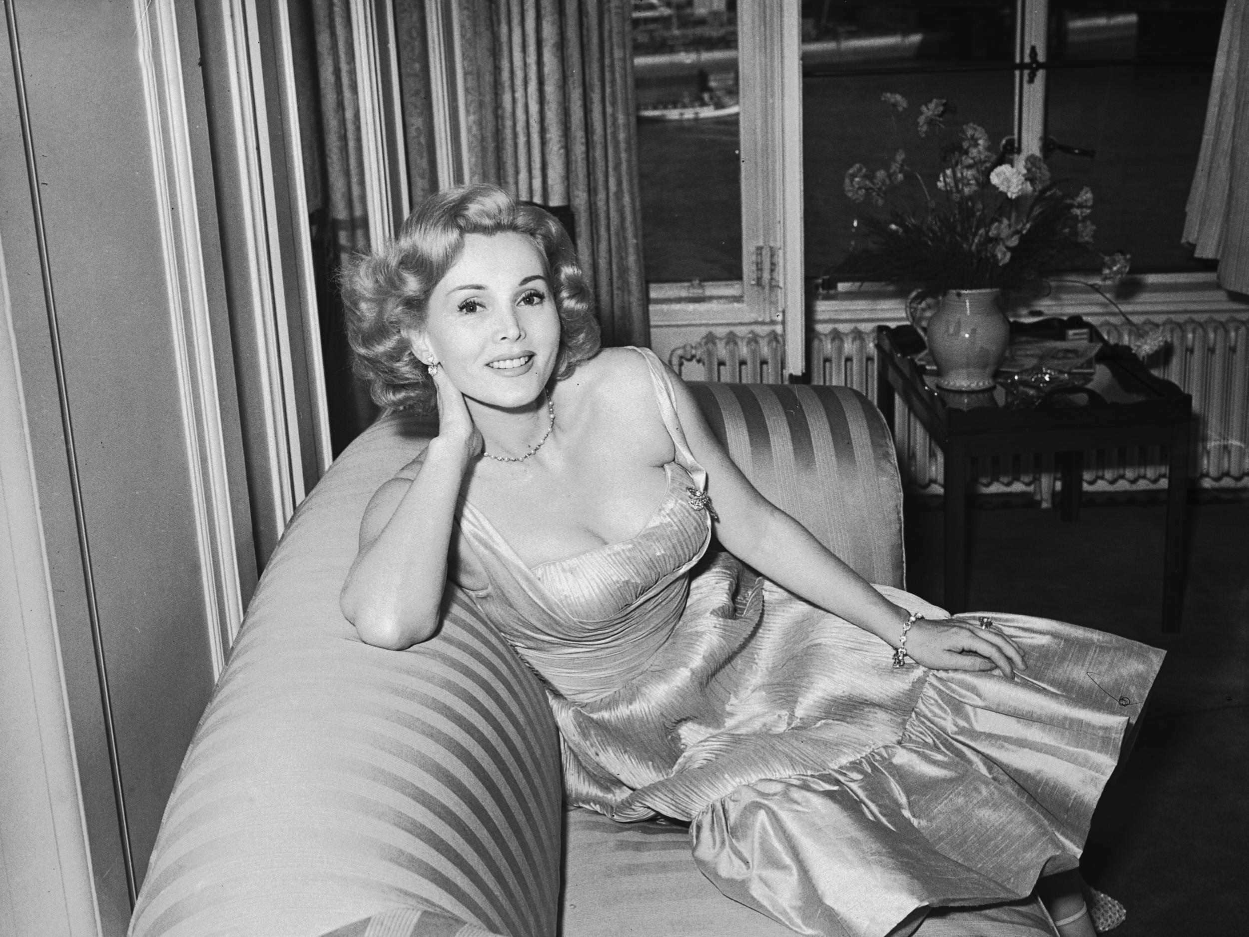 8th July 1952: Hungarian actress Zsa Zsa Gabor lounges on a sofa in a ruched evening gown