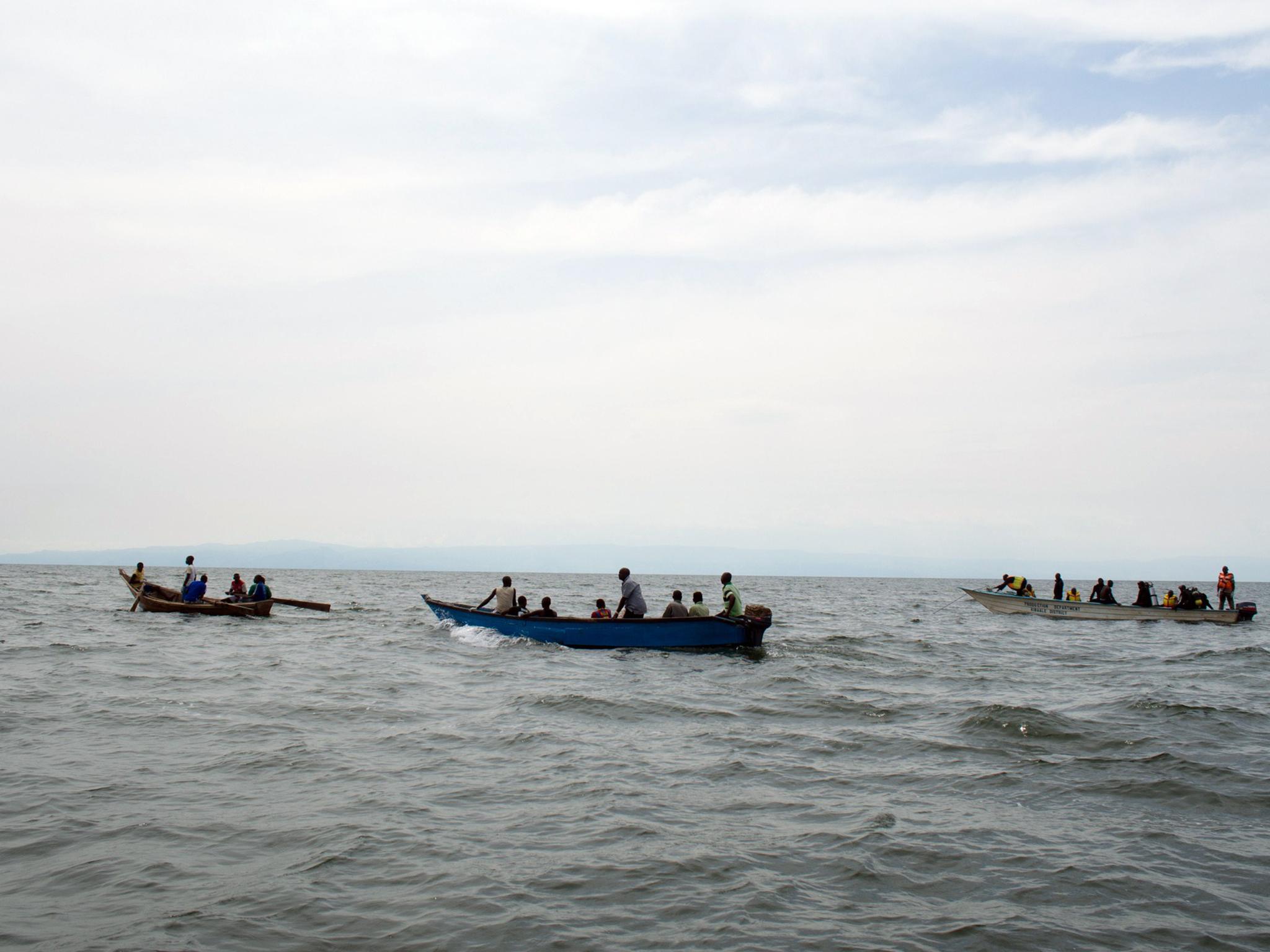 Uganda Police divers and local fishermen search for victims of a boat disaster on Lake Albert on 23 March, 2013
