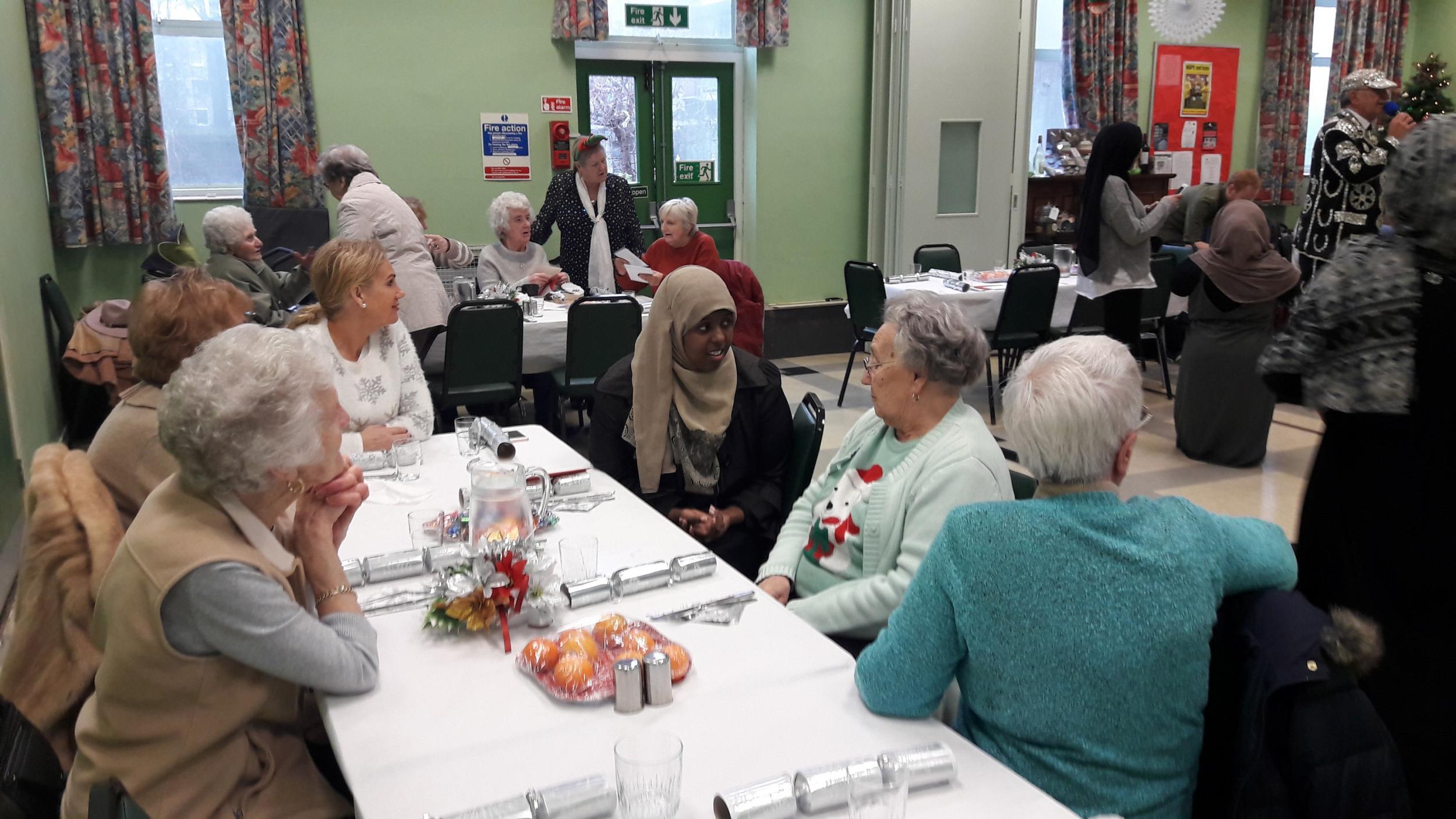 A Muslim Aid volunteer chats with the women at the event