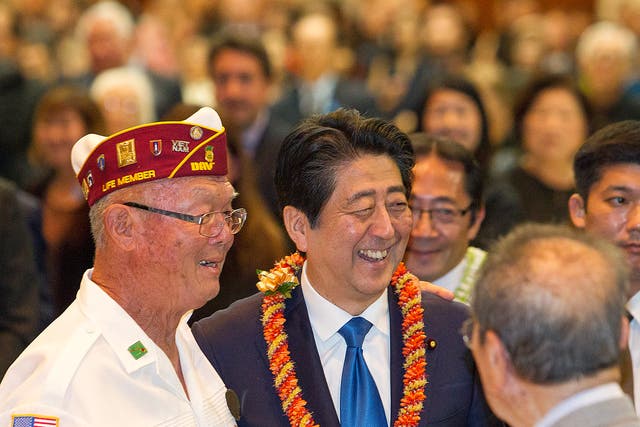 Japanese Prime Minister Shinzo Abe, center, greets guests at a dinner held in Abe's honour in Honolulu, Hawaii