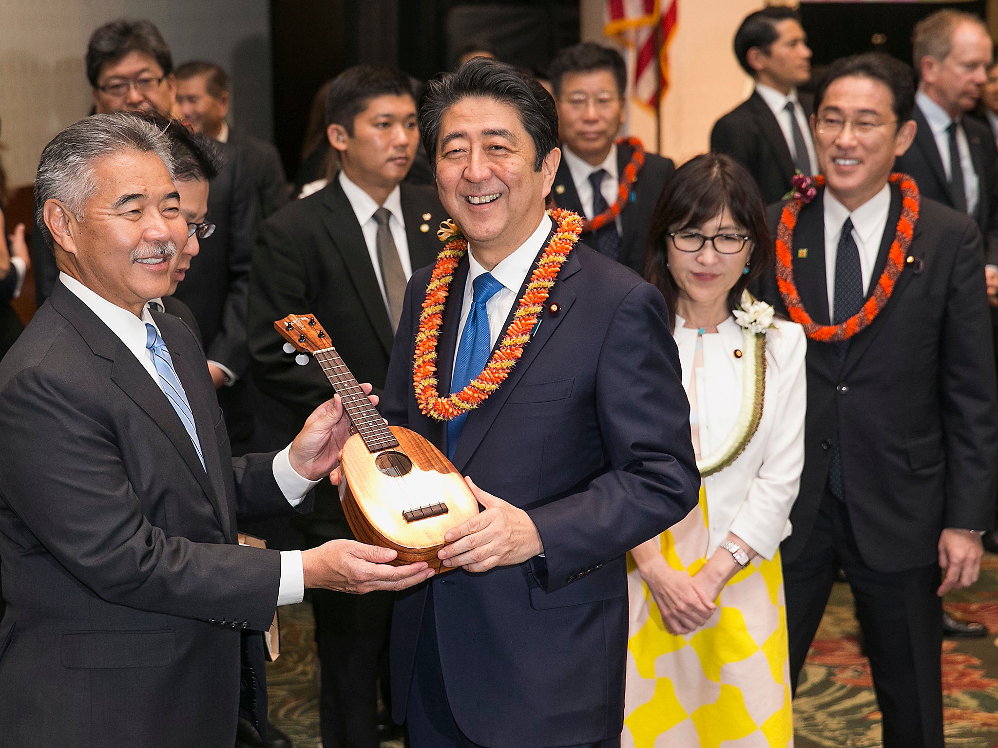Hawaii Gov. David Ige, left, presents Japanese Prime Minister Shinzo Abe a pineapple-shaped ukulele at a dinner held in Abe's honour in Honolulu, Hawaii