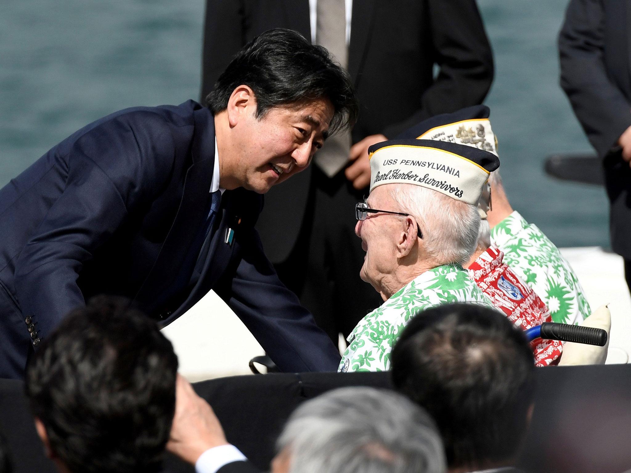 Shinzo Abe smiles hugs Pearl Harbour survivor Everett Hyland at Kilo Pier overlooking the USS Arizona Memorial at Joint Base Pearl Harbor-Hickam in Honolulu