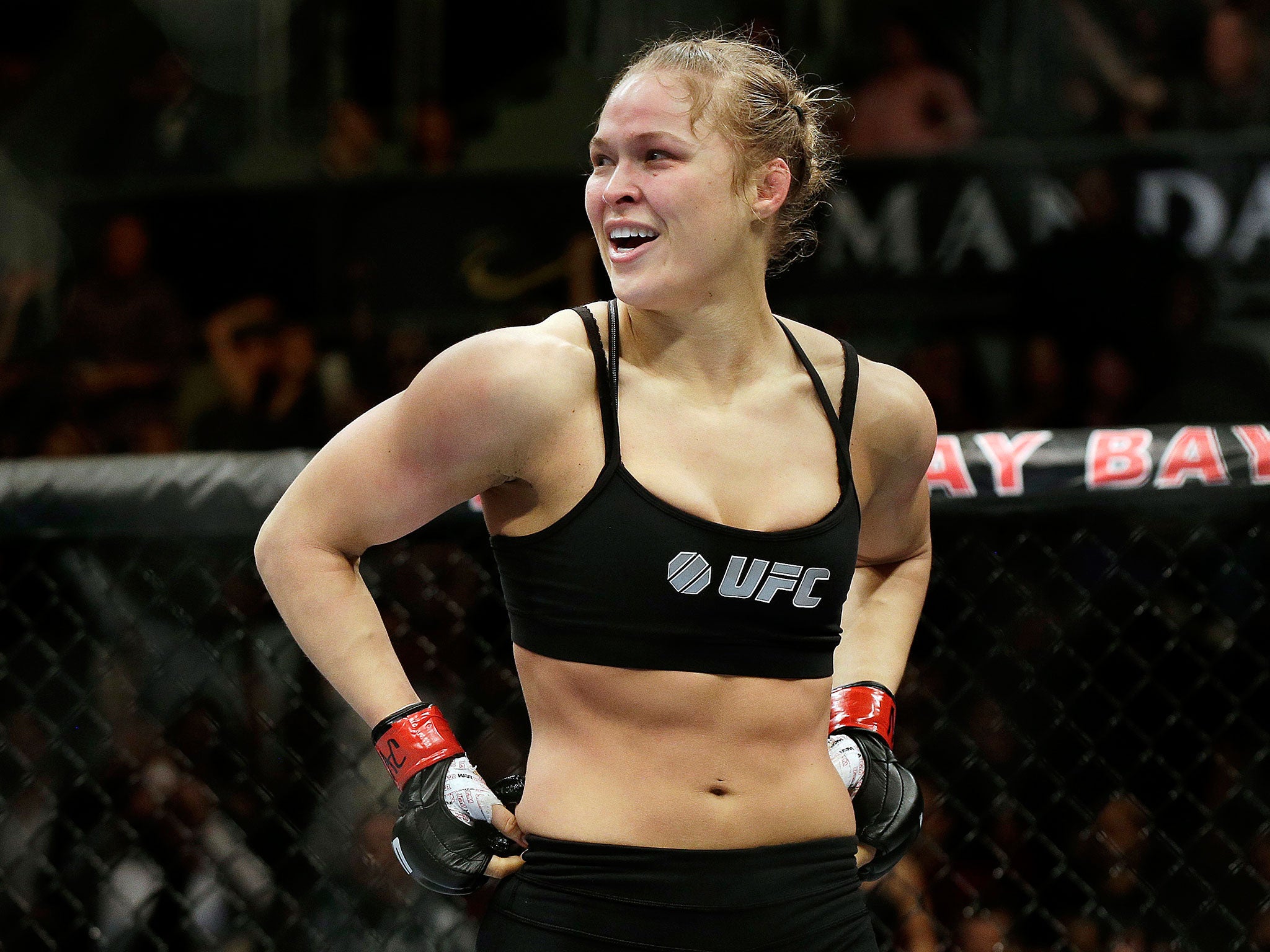 Rousey stands triumphant following her victory against Sara McMann in UFC 170