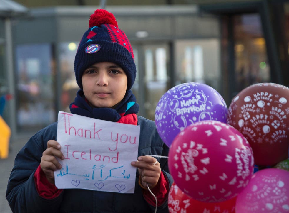 A young Syrian boy holds a sign reading 'Thank you Iceland' at Keflavik airport in January 2016