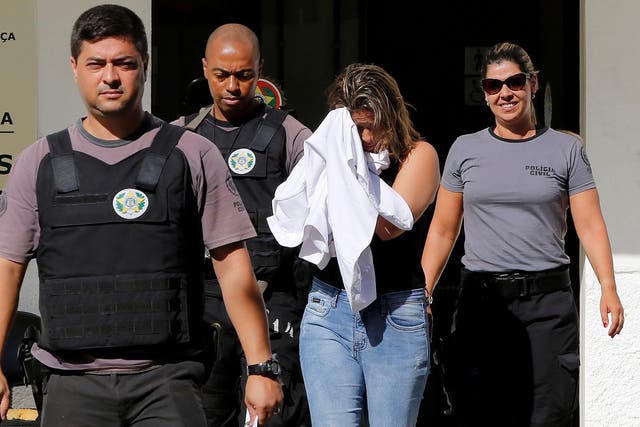 Francoise Souza Oliveira, 40, wife of Greek Ambassador for Brazil Kyriakos Amiridis, is escorted by police officers as she is transferred from the police station to a jail in Belford Roxo, Brazil, 31 December, 2016