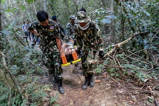 Muriel Benetulier is transported on a stretcher by Thai Park Rangers after she was bitten by after she was bitten by a crocodile
