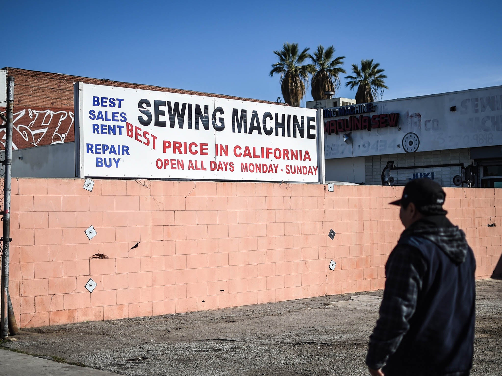 A man walks past a factory in the Garment District of Los Angeles