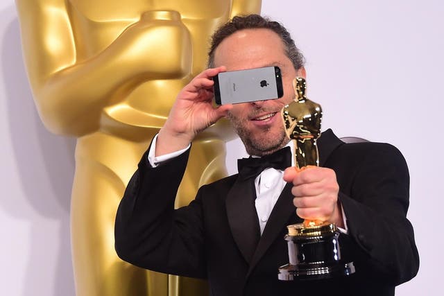 Emmanuel Lubezki, winner for the Best Cinematography Award for 'Birdman' takes a photo in the press room during the 87th Oscars on February 22, 2015 in Hollywood, California
