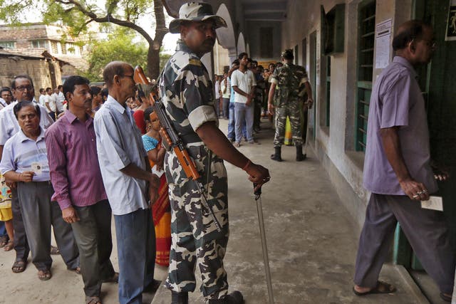 A policeman looks on as voters line up to cast their vote at a polling station during the fourth phase of West Bengal Assembly elections on the outskirts of Kolkata, India, April 25, 2016