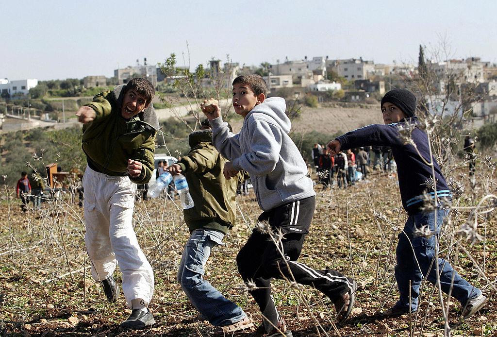 Palestinian children throw stones during a demonstration near the West Bank village of Zbobah in a file photo from January 2008