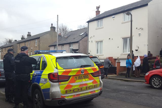 Armed police officers outside Mohammed Yassar Yaqub's home in the Crosland Moor area of Huddersfield