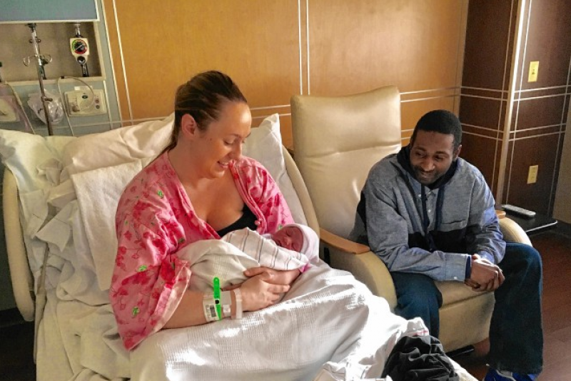 Lamar and Lindsay Austin resting with their newborn baby, Cainin