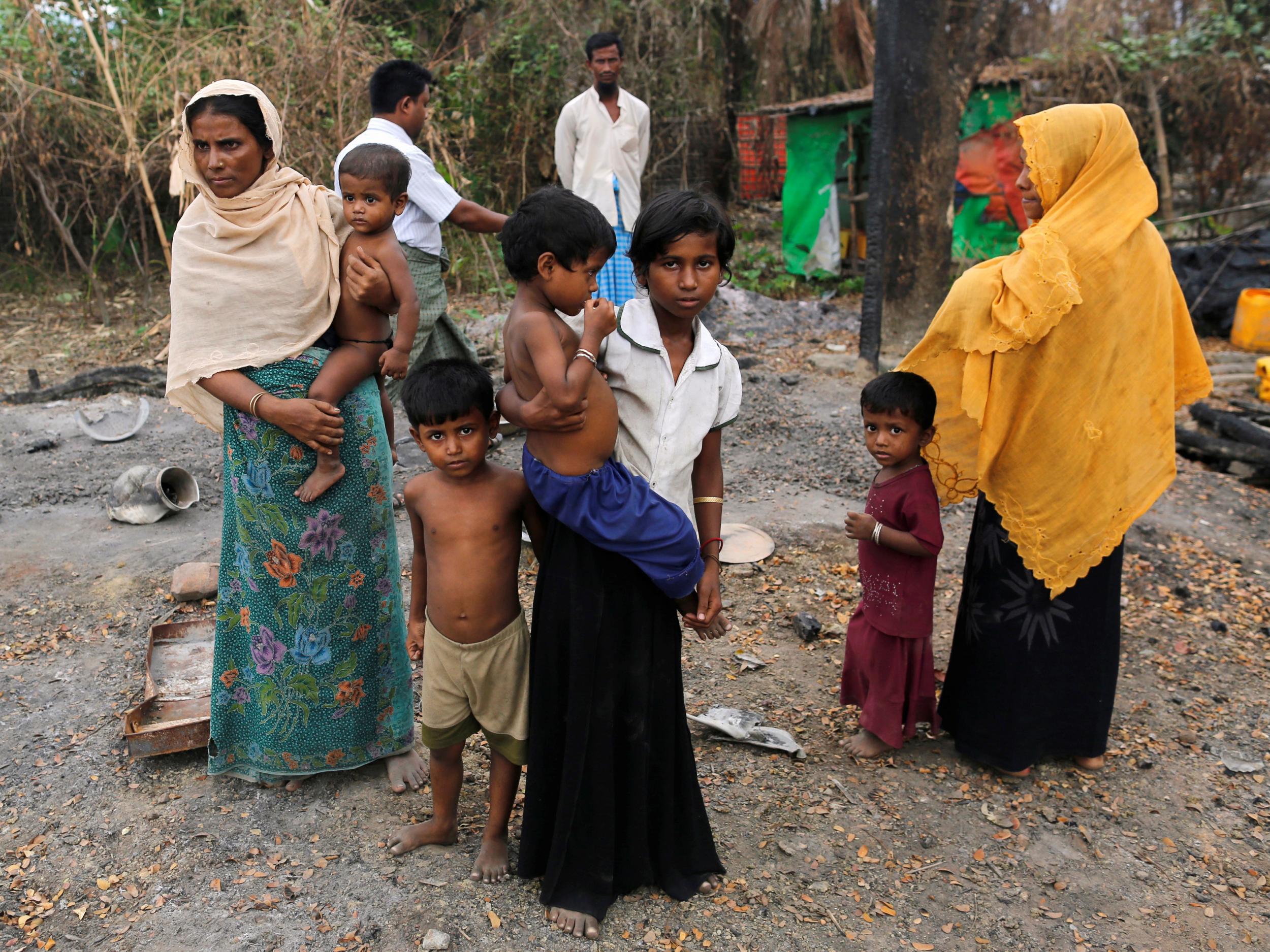 File image: A family stands beside remains of a market which was set on fire, in Rohingya village outside Maungdaw, in Rakhine state