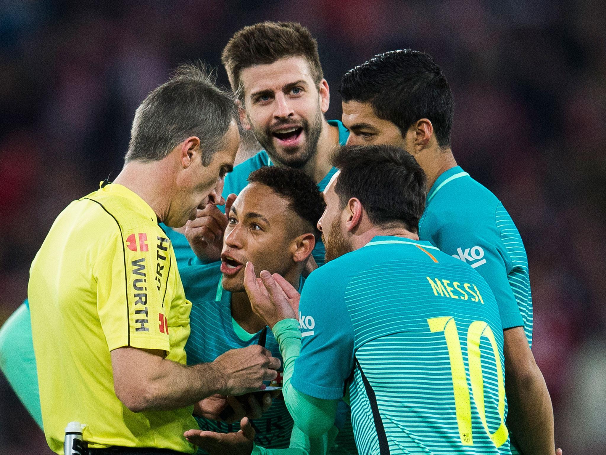 Barcelona players remonstrate with referee Fernandez Borbalan