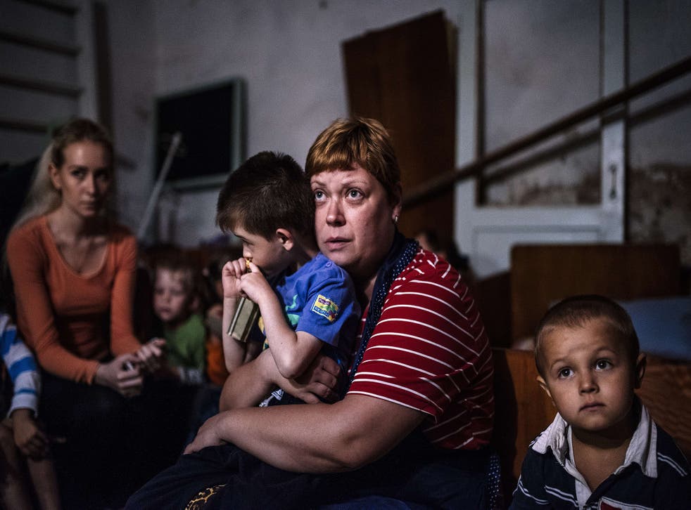 Children and teachers hide in a bomb shelter in an orphanage during a shelling in the town of Makiyivka in 2014
