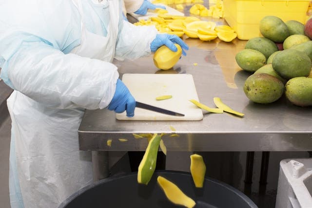 A worker at Baldor processes mangoes
