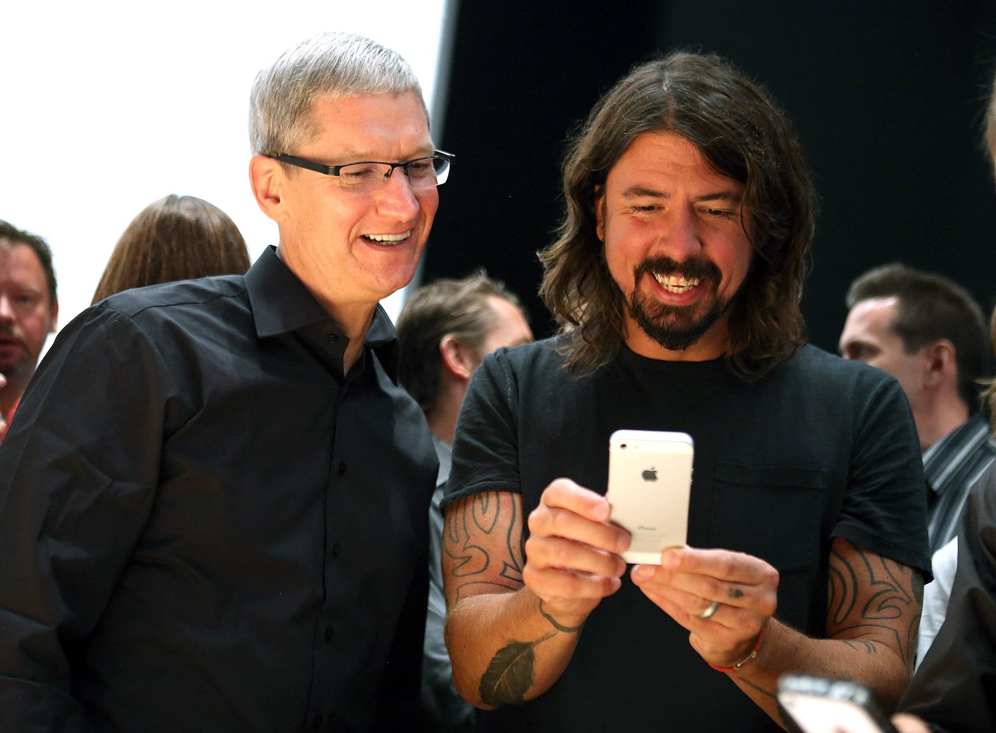 Apple CEO Tim Cook and Dave Grohl of the Foo Fighters look at the new iPhone 5 during an Apple special event