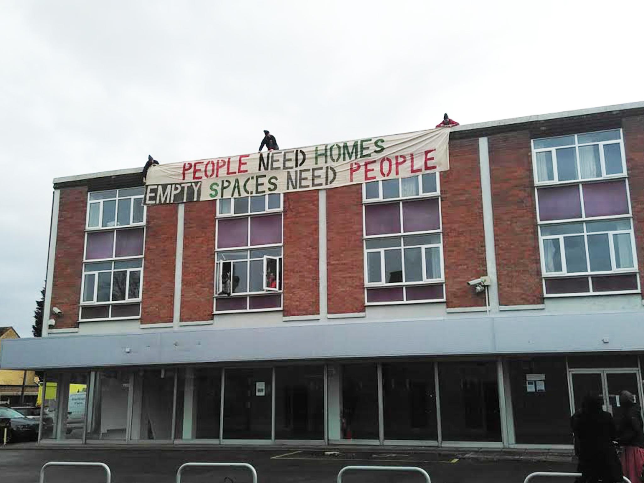 Activists drop a banner from the Iffley Road building, owned by Wadham college