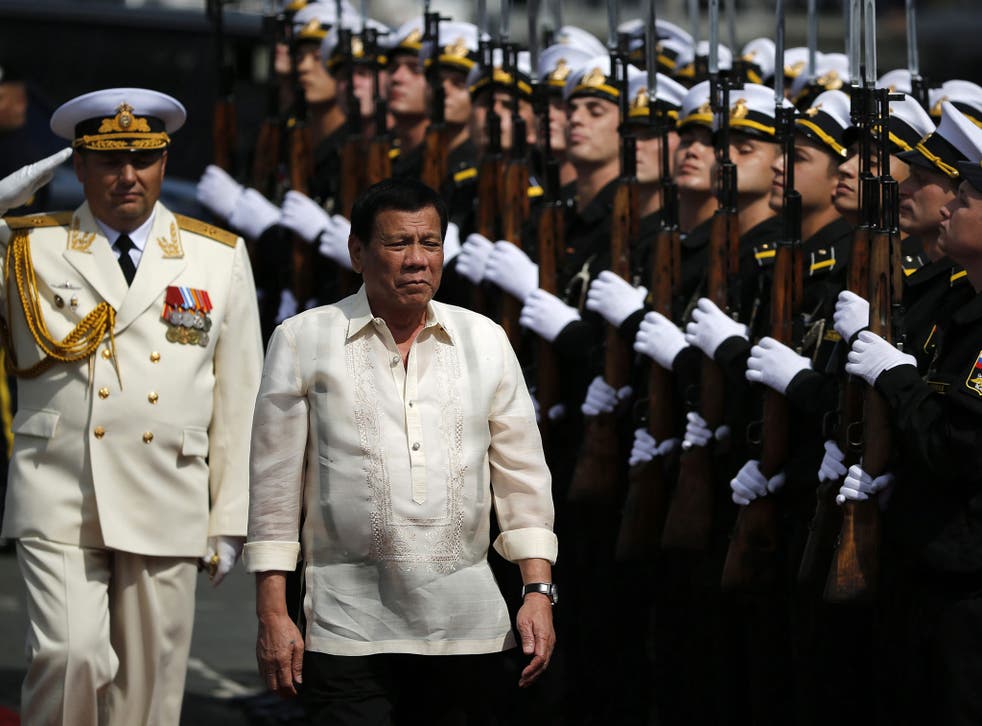 President Rodrigo Duterte walks with Russian Rear Admiral Eduard Mikhailov (L) as he boards a Russian navy anti-submarine vessel in Manila on 6 January 2017