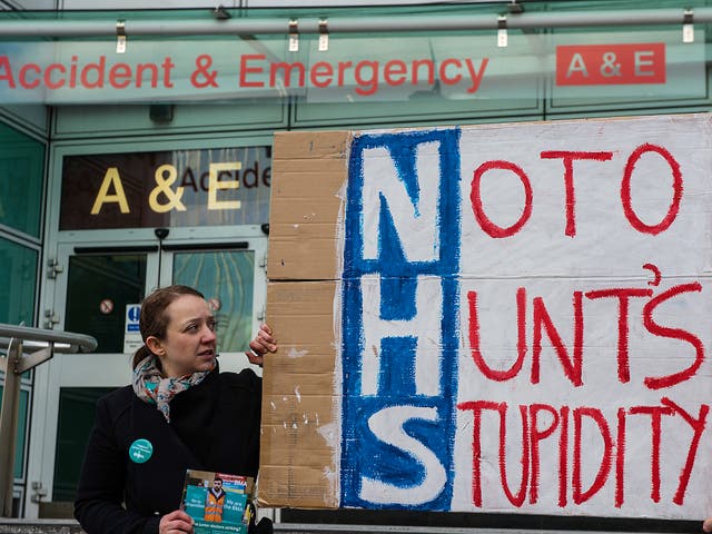 Junior doctor Dr Sioned Phillips holds a homemade placard outside the accident and emergency entrance at University College Hospital in central London