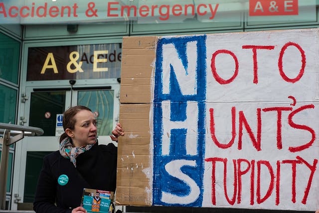 Junior doctor Dr Sioned Phillips holds a homemade placard outside the accident and emergency entrance at University College Hospital in central London