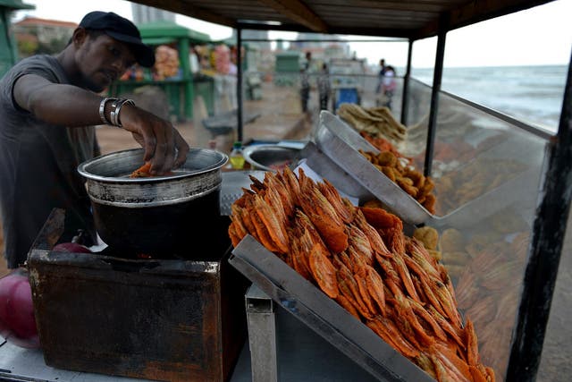 A vendor sells street snack isso vadei on Galle Face Beach