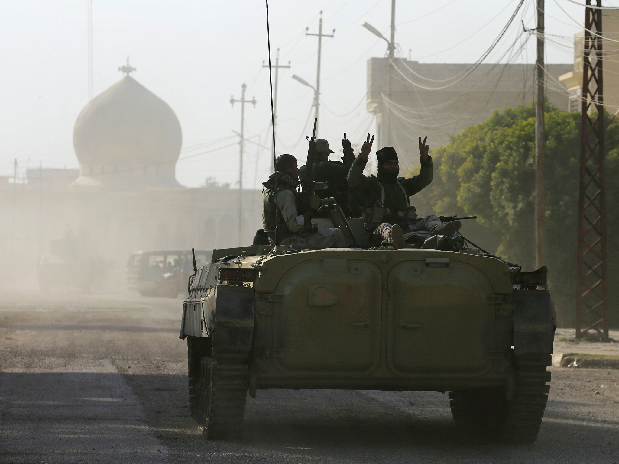 Iraqi rapid response forces ride on an armoured vehicle during a battle with Isis militants east of Mosul, Iraq, 14 January 2017