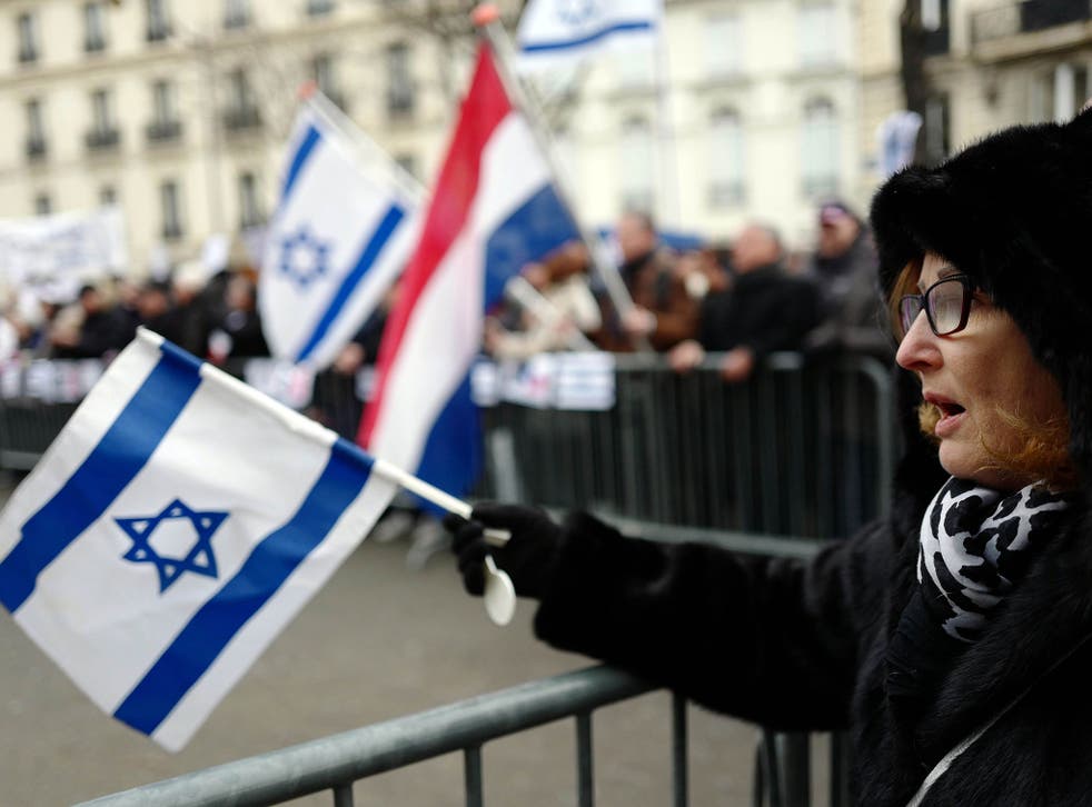Demonstrators wave flags and shout slogans during a rally in Paris on January 15, 2017 against the Paris Middle East peace conferenc