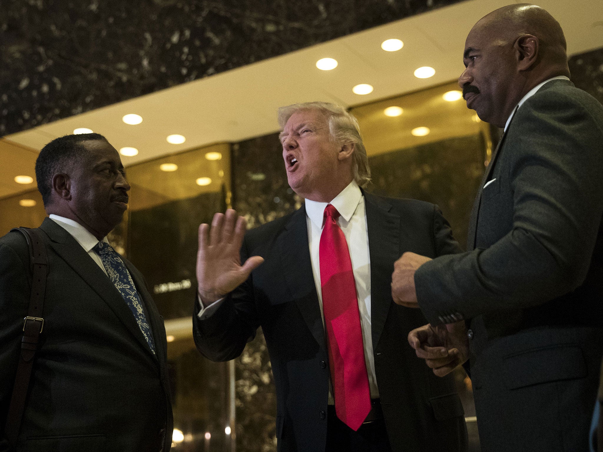 President-elect Donald Trump (C) and television personality Steve Harvey (R) speak to reporters after their meeting at Trump Tower on 13 January, 2017