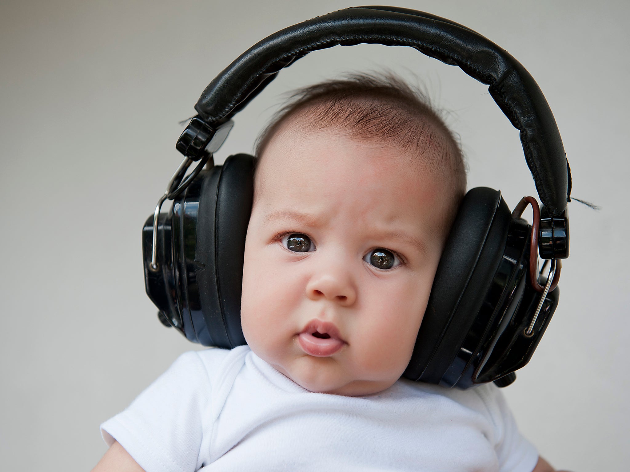 A baby listens to music through headphones