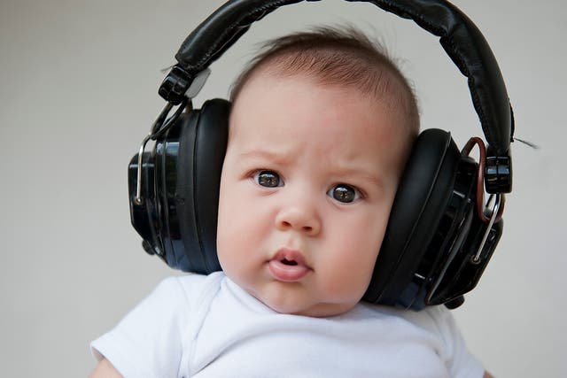 A baby listens to music through headphones