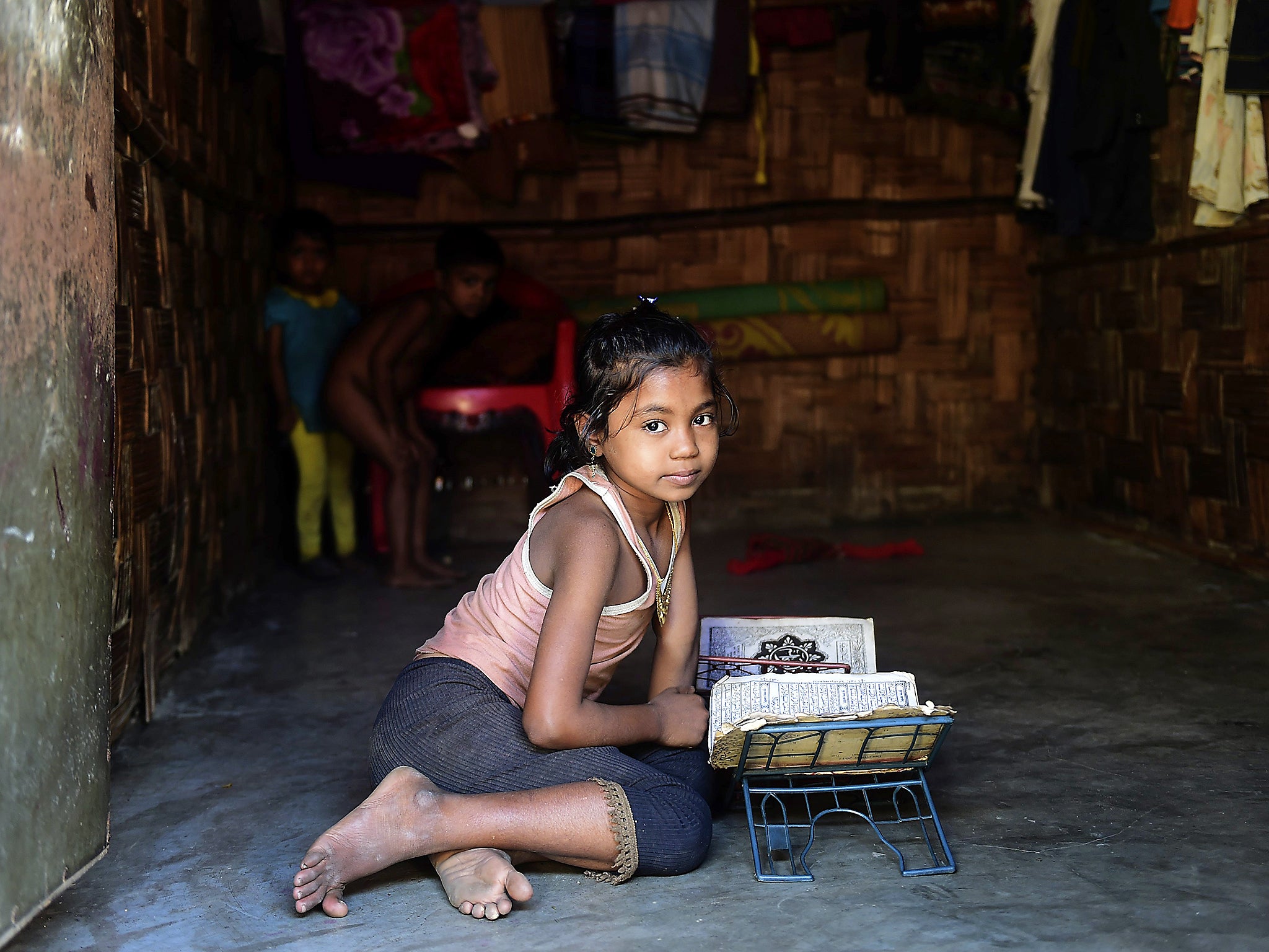 A Burmese Rohingya girl reads the Quran at a refugee camp in Teknaf of southern Cox’s Bazar district (Getty)