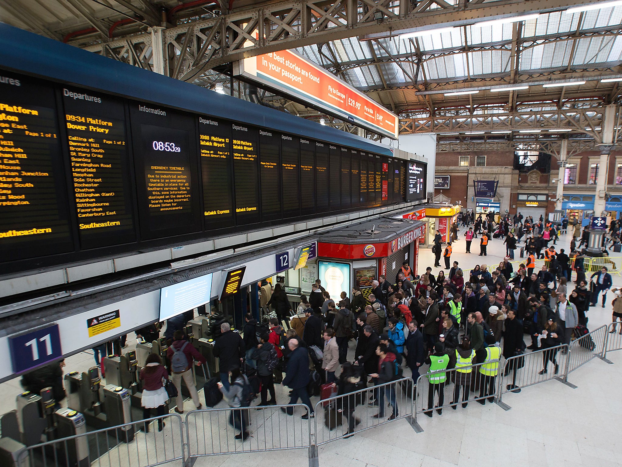 Commuters queue to take a train to Gatwick as strike action affects service at Victoria station in London