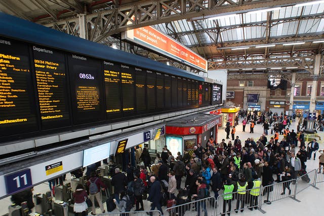 Commuters queue to take a train to Gatwick as strike action affects service at Victoria station in London